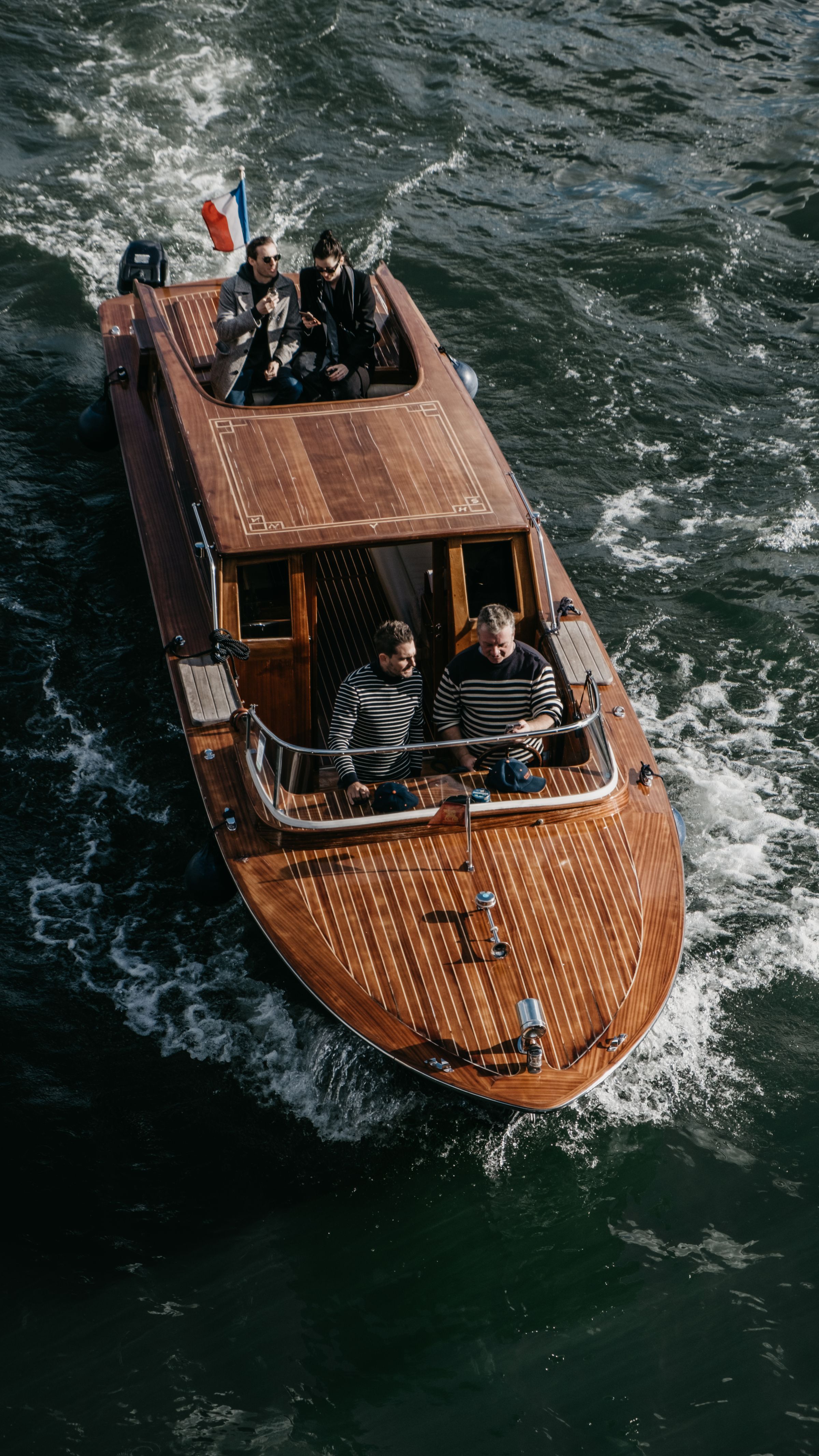 A mahogany Cuddy Cabin with forward cabin, cruising on calm water.