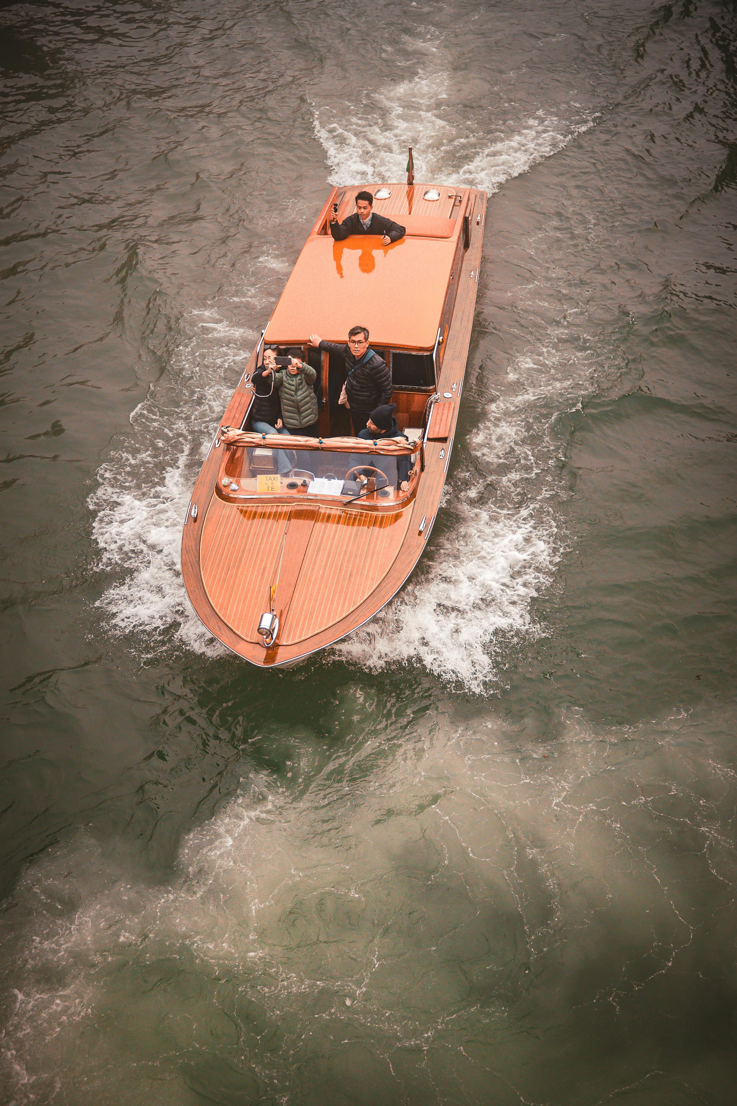 Aerial view of a polished mahogany Runabout cruising on open water.