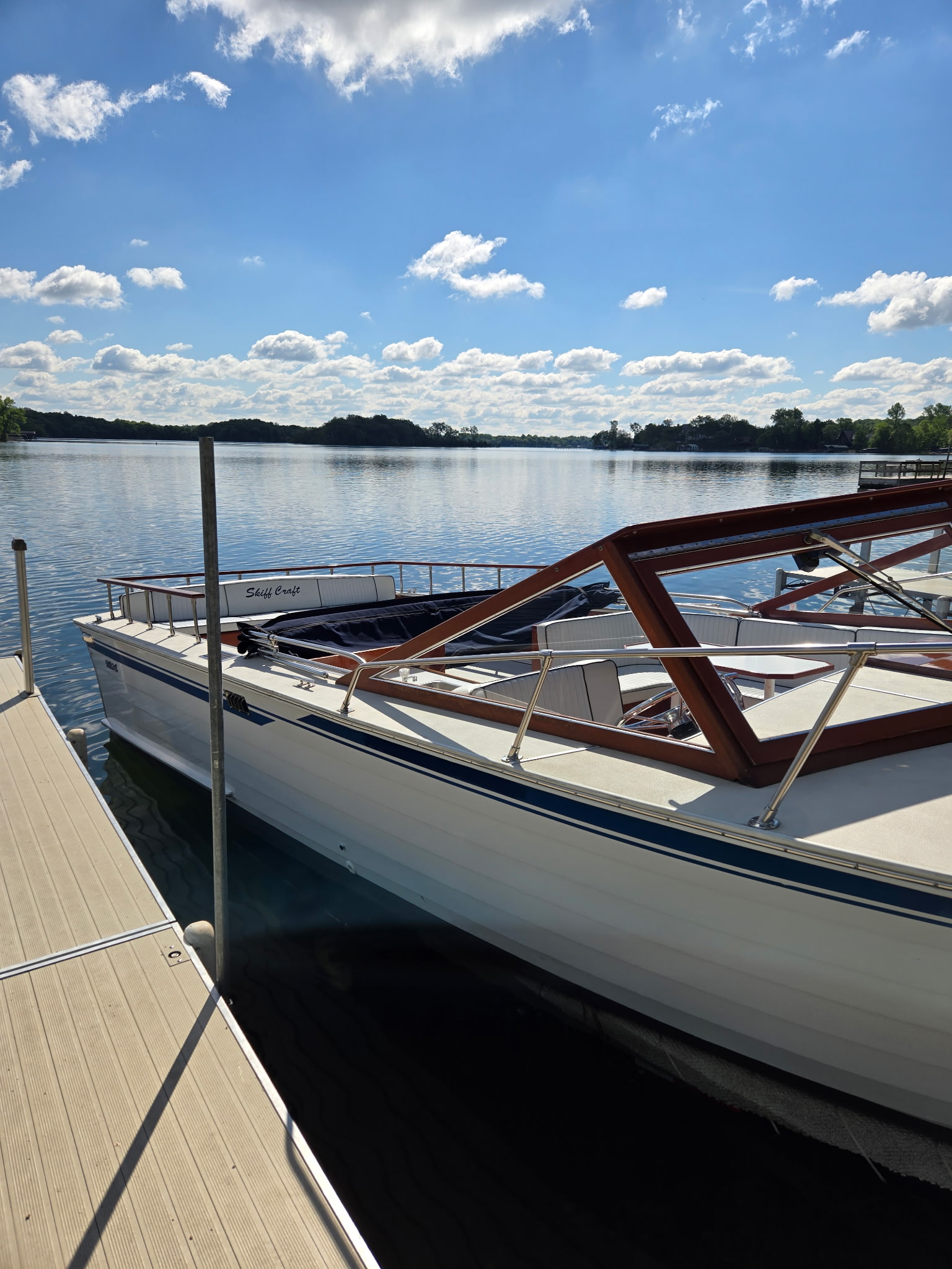 Skiff Craft at dock under a dramatic blue sky with white clouds.