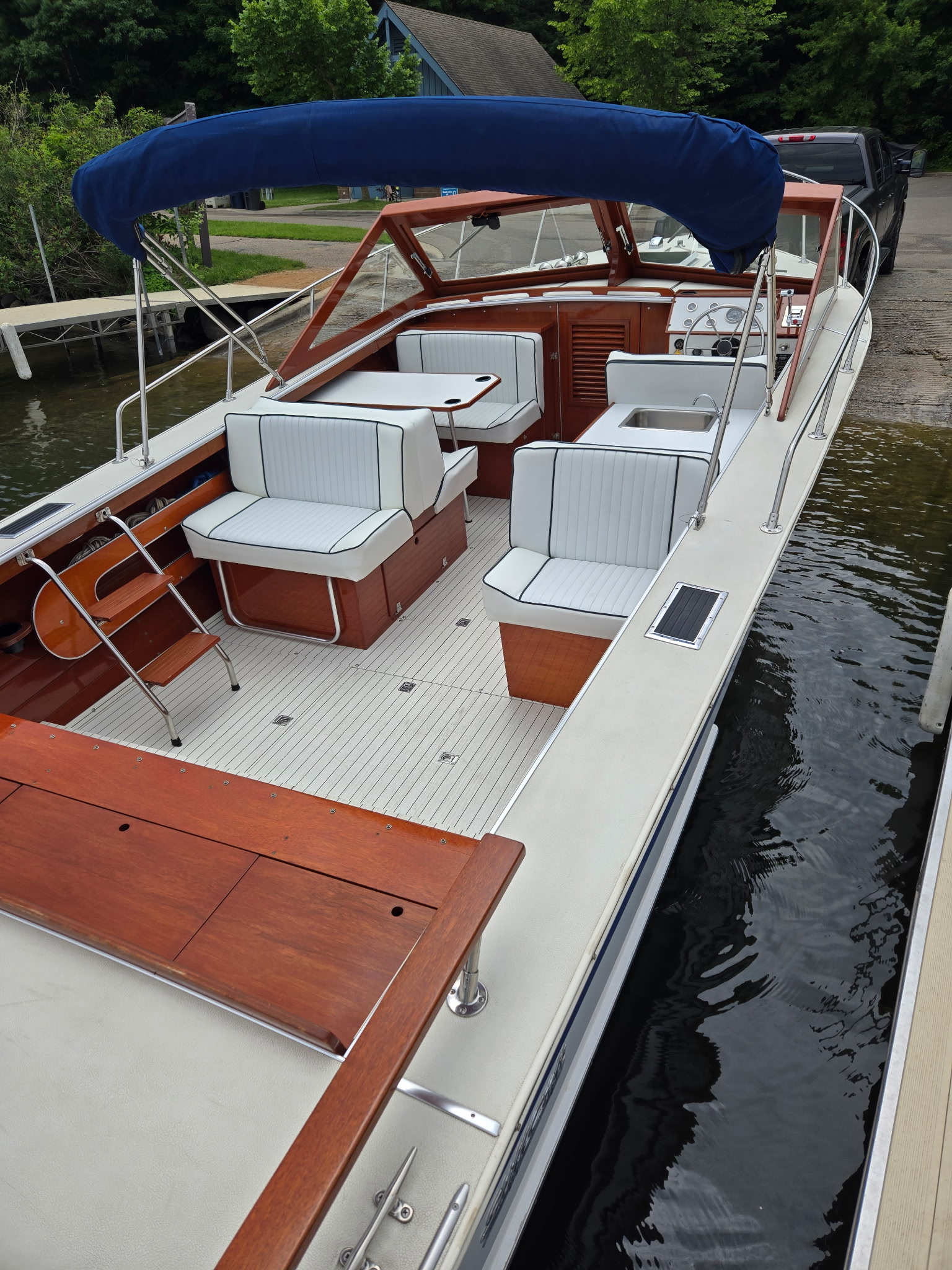Overhead view of Skiff Craft interior — white upholstered seating, mahogany trim, teak deck.