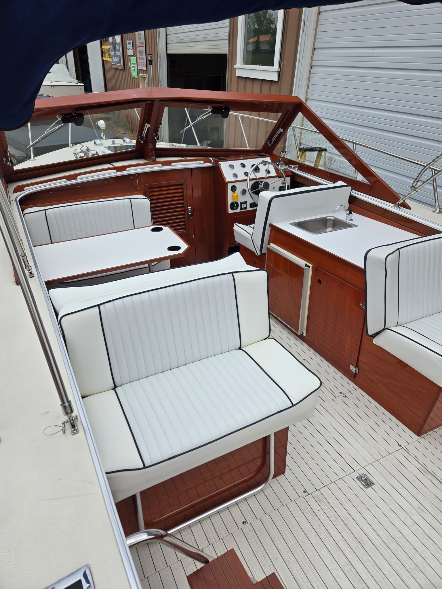 Skiff Craft Cuddy Cabin interior — forward cabin with mahogany cabinetry and white upholstery.