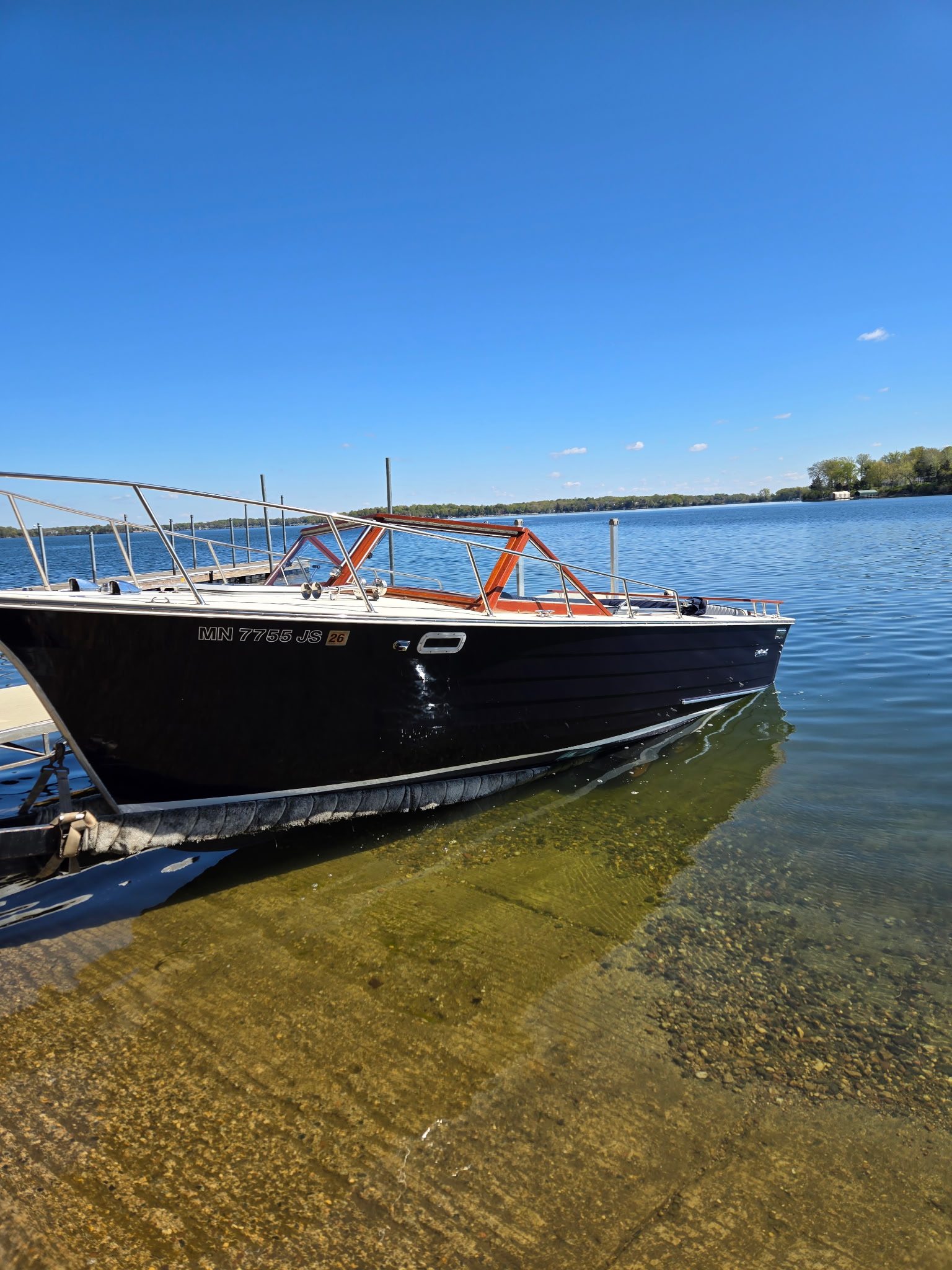 Skiff Craft on crystal-clear water under a deep blue Minnesota sky.