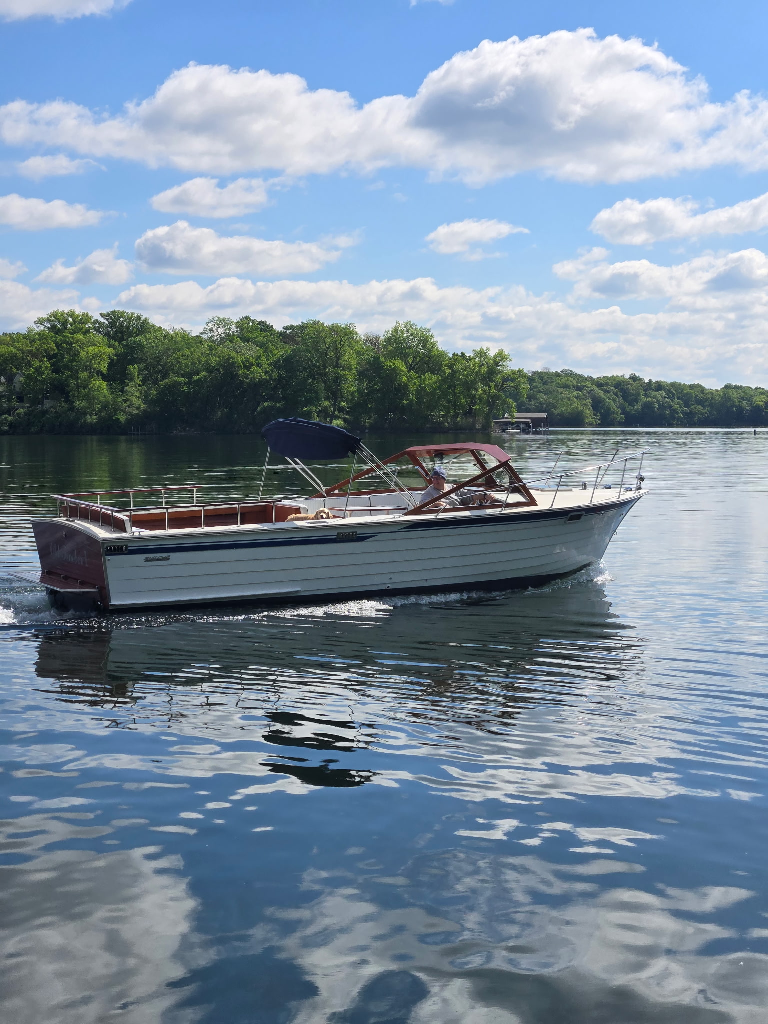 Skiff Craft runabout underway on a Minnesota lake on a sunny summer day.